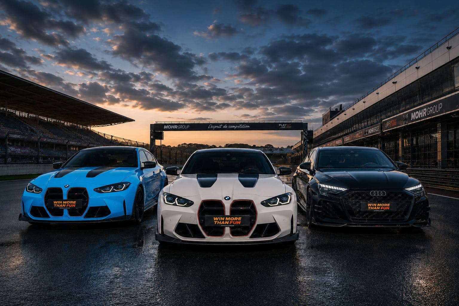 Three sports cars — two BMWs and an Audi — lined up on a race track